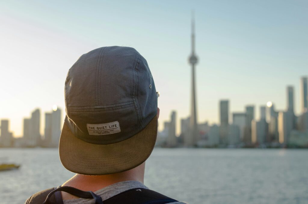 Joven observando el skyline urbano de una ciudad en Canadá, simbolizando nuevas oportunidades laborales.